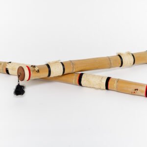 Two handmade bamboo fly fishing rod cases crossed over each other, featuring black and red painted bands, cream rope wrappings, and wooden caps with tassels on a white background.