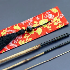 Hand-built 1.78 meter bamboo Tanago rod for micro-fishing, featuring a sculpted ergonomic artisan handle and a red dragon-patterned fabric protector, handcrafted in Spain.