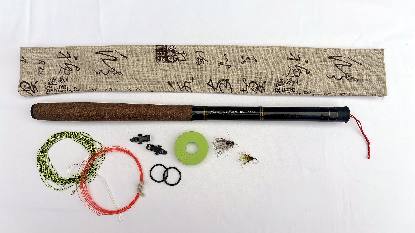 Handmade tenkara rod R22 extended next to its sleeve, line, flies and accessories